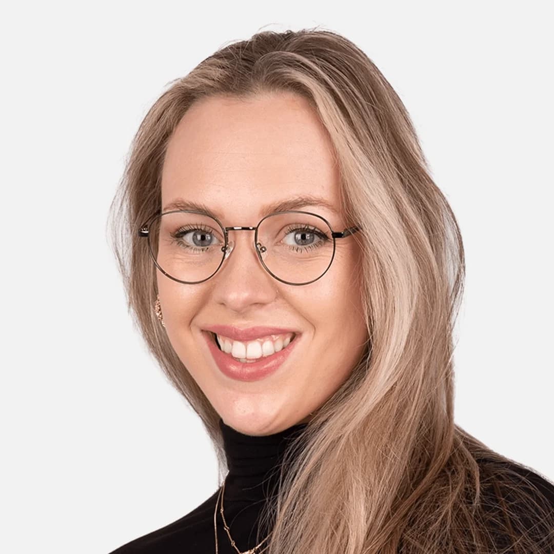Close-up of a smiling woman wearing eyeglasses with anti-reflective lenses. Her eyes are clearly visible without any reflections on the lenses, demonstrating how anti-reflective coatings eliminate glare, ensure eye visibility, and allow for flawless photos without blurriness or light interference.